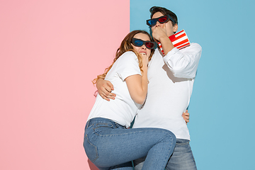 Image showing Young emotional man and woman on pink and blue background