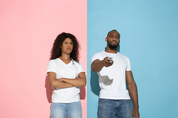 Image showing Young emotional man and woman on pink and blue background