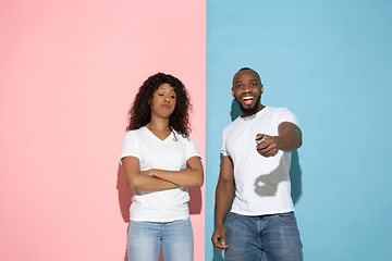 Image showing Young emotional man and woman on pink and blue background