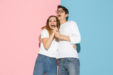 Image showing Young emotional man and woman on pink and blue background