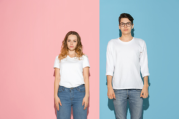 Image showing Young emotional man and woman on pink and blue background