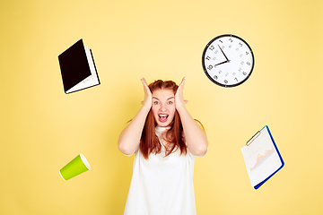 Image showing Caucasian young woman\'s portrait on yellow background, too much tasks