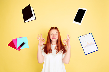 Image showing Caucasian young woman\'s portrait on yellow background, too much tasks