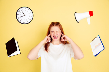 Image showing Caucasian young woman\'s portrait on yellow background, too much tasks