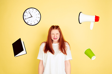 Image showing Caucasian young woman\'s portrait on yellow background, too much tasks