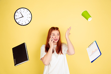 Image showing Caucasian young woman\'s portrait on yellow background, too much tasks