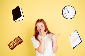 Image showing Caucasian young woman\'s portrait on yellow background, too much tasks