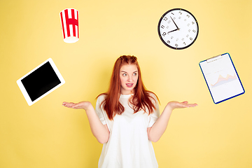 Image showing Caucasian young woman\'s portrait on yellow background, too much tasks