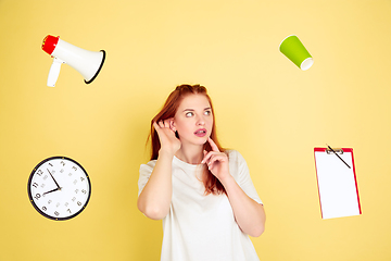 Image showing Caucasian young woman\'s portrait on yellow background, too much tasks