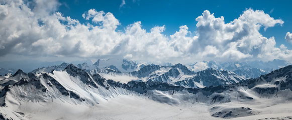 Image showing Mountain clouds over beautiful snow-capped peaks of mountains an