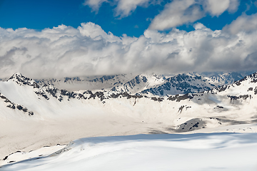 Image showing Mountain clouds over beautiful snow-capped peaks of mountains an