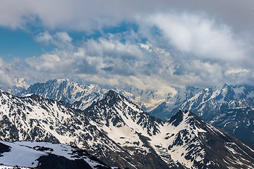 Image showing Mountain clouds over beautiful snow-capped peaks of mountains an