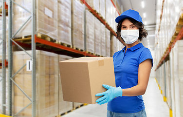 Image showing delivery woman in face mask holding parcel box