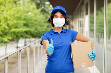 Image showing delivery woman in mask holding parcel box outdoors