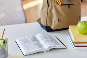 Image showing books, apple and school supplies on table at home