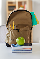 Image showing school backpack with books and apple on table