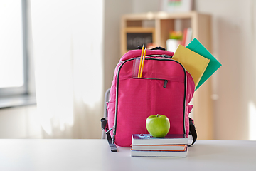 Image showing pink backpack, apple and school supplies on table