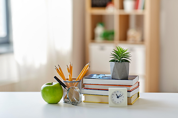 Image showing books, magnifier, pencils, apple on table at home
