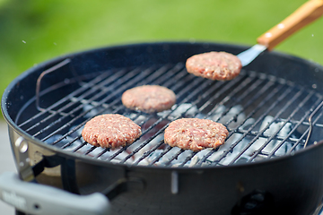 Image showing close up of meat cutlets roasting on grill