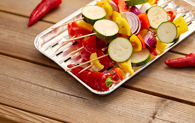 Image showing close up of vegetables on skewers on foil grill