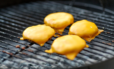 Image showing close up of meat cutlet with cheese on grill