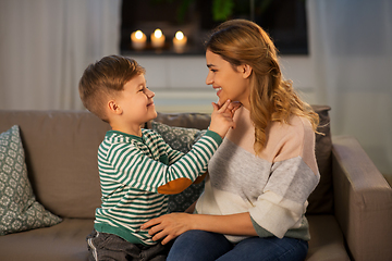 Image showing happy smiling mother talking to her son at home