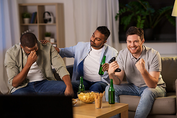 Image showing happy friends playing video games at home at night