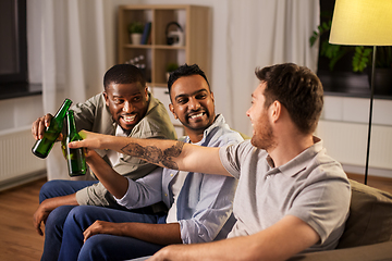Image showing happy male friends drinking beer at home at night