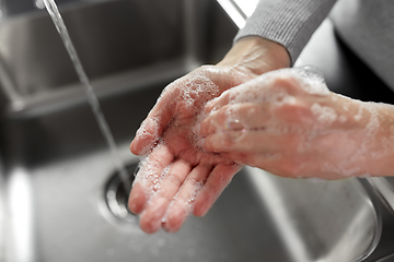 Image showing woman washing hands with soap in kitchen