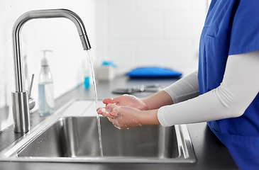 Image showing doctor or nurse washing hands with liquid soap