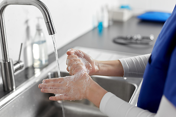 Image showing doctor or nurse washing hands with liquid soap