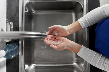 Image showing doctor or nurse washing hands with liquid soap