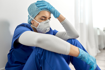 Image showing sad doctor or nurse in face mask holding to head