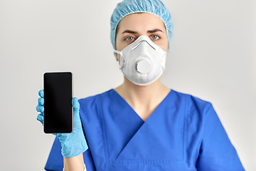 Image showing doctor in goggles and face mask with smartphone