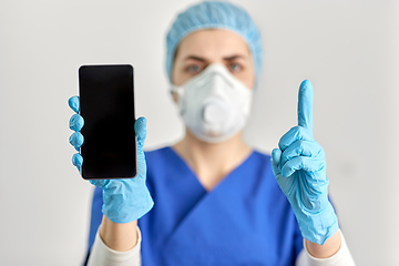 Image showing doctor in goggles and face mask with smartphone