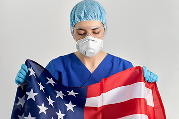 Image showing doctor in goggles and mask holding flag of america