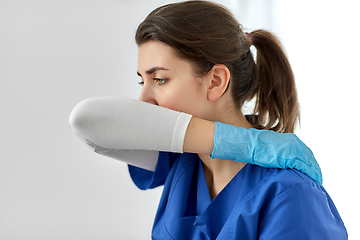 Image showing doctor or nurse coughing covering mouth with elbow