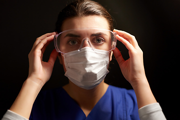 Image showing female doctor or nurse in goggles and face mask