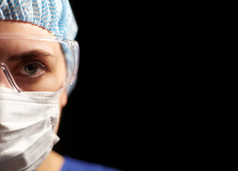 Image showing female doctor or nurse in goggles and face mask