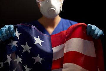 Image showing doctor in goggles and mask holding flag of america