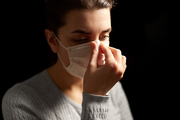 Image showing sick woman adjusting protective medical face mask