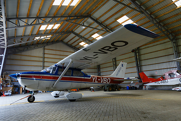 Image showing outdoor shot of small plane standing in shed