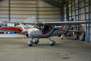 Image showing outdoor shot of small plane standing in shed