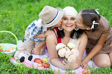 Image showing mother with two kids having picnic outdoors