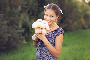 Image showing beautiful teen age girl holding flowers