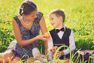 Image showing Little boy and teen age girl having picnic outdoors