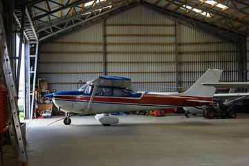 Image showing outdoor shot of small plane standing in shed