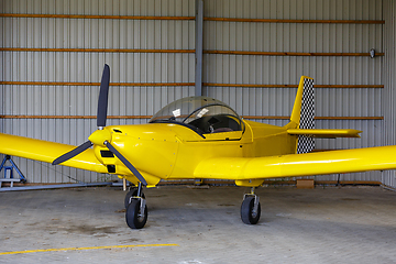 Image showing outdoor shot of small plane standing in shed