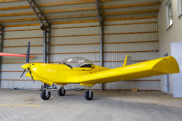 Image showing outdoor shot of small plane standing in shed