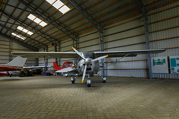 Image showing outdoor shot of small plane standing in shed